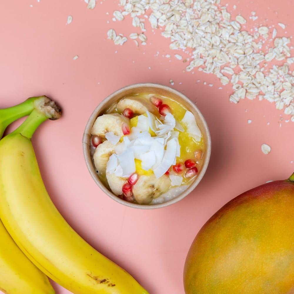 Wähle aus den unseren Porridge: MANGO DREAM mit Porridge mit Mango-Kompott, Granatapfel und Kokoschips