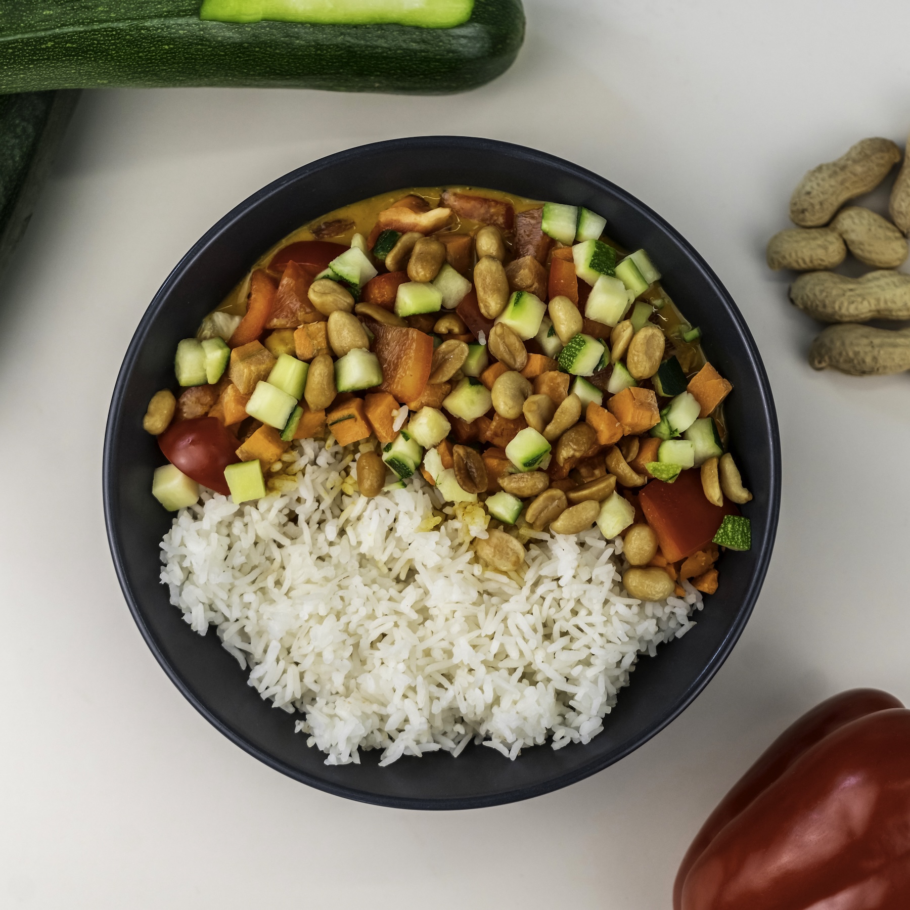Wähle aus der Kategorie Hot Bowls: THAI CURRY mit Basis: Reis. Gelbes Curry, Edamame, Mais, Möhren und Erdnüssen.